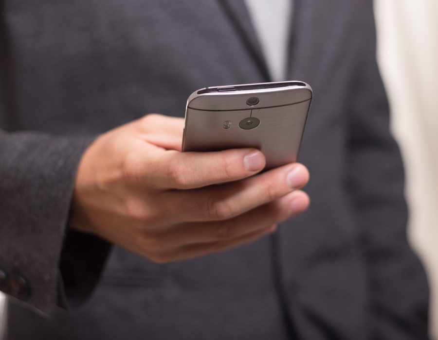 手机屏幕特写，mods App 的资源核验页显示版本号与来源标注，手指正停在核验状态标签上
